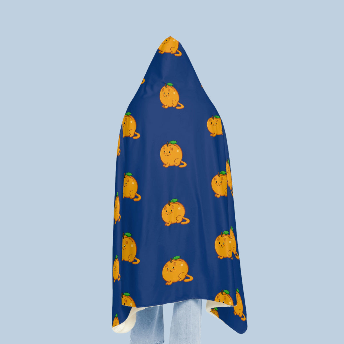 Happy woman wearing the dark blue Apricat⢠hooded microfiber fleece blanket seen from behind. Apricat⢠is an apricot drawn as a cute cat.