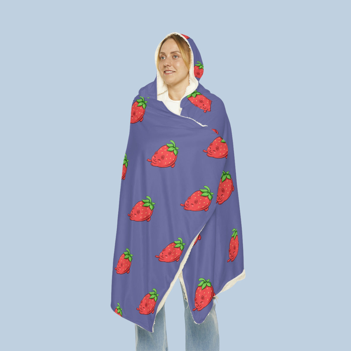 Happy woman wearing the purple Clawberry⢠hooded microfiber fleece blanket seen from front. Clawberry⢠is a strawberry drawn as a cute cat.