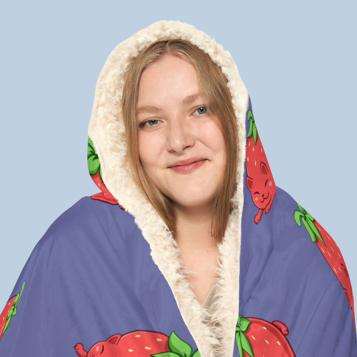 Happy woman wearing the purple Clawberry⢠hooded sherpa blanket face zoomed in. Clawberry⢠is a strawberry drawn as a cute cat.