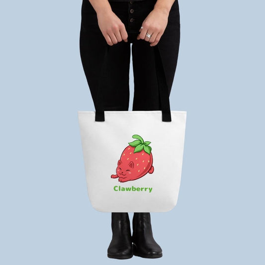 Person holding a white Tote Bag with Clawberry⢠print. Clawberry⢠is a strawberry drawn as a cute cat.