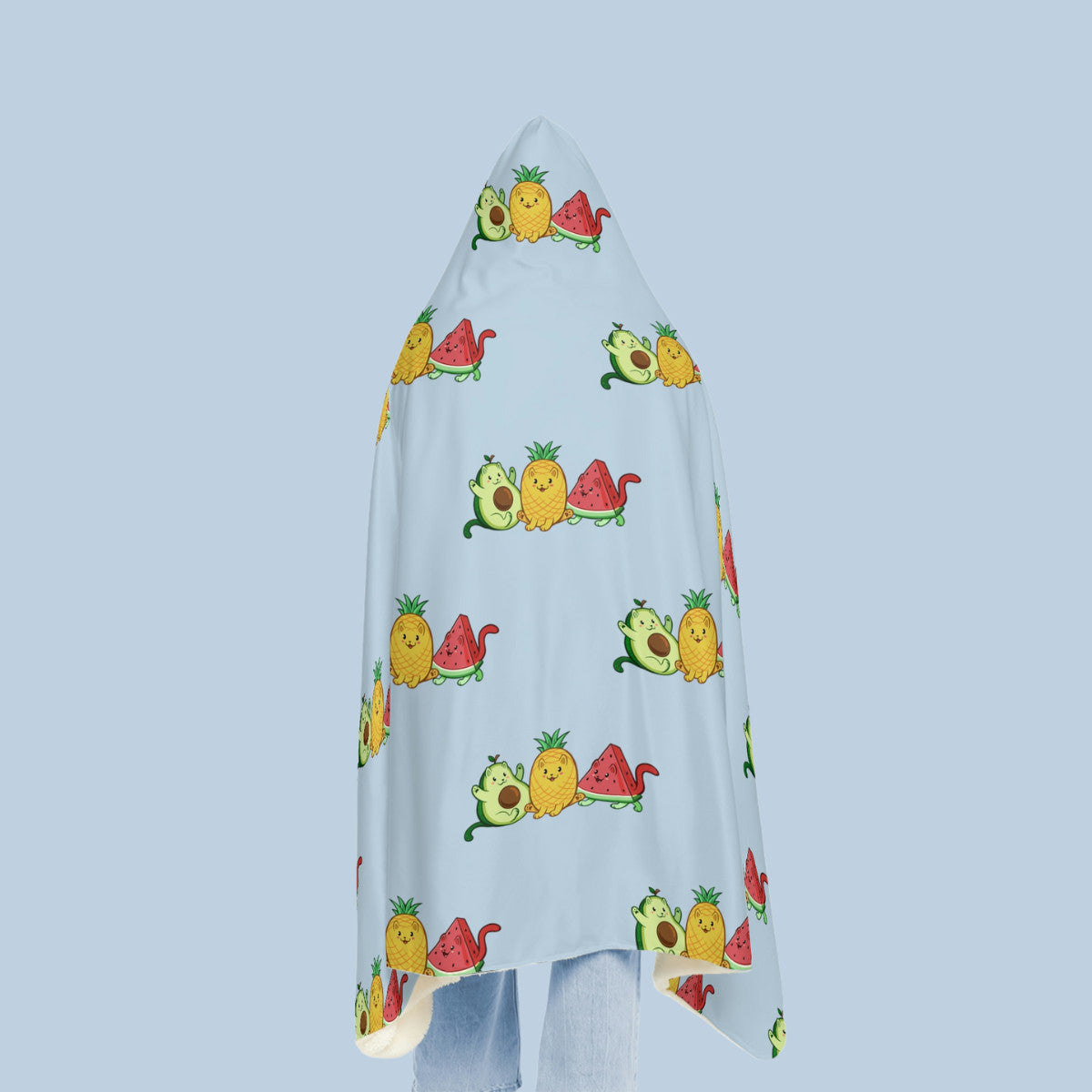 Happy woman wearing the light blue Fruitkittens⢠logo hooded microfiber fleece blanket seen from behind. Fruitkittens⢠are fruits drawn as cute cats. The logo features Pawocadoâ˘, Pawnapple⢠and Watermewlonâ˘