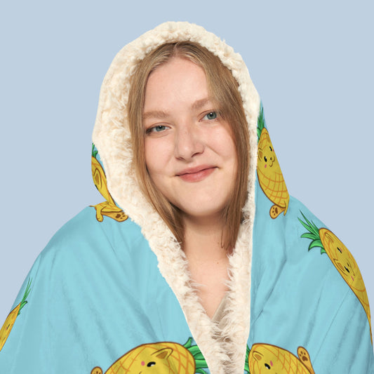 Happy woman wearing the light blue Pawnapple⢠hooded sherpa blanket face zoomed in. Pawnapple⢠is a pineapple drawn as a cute cat.