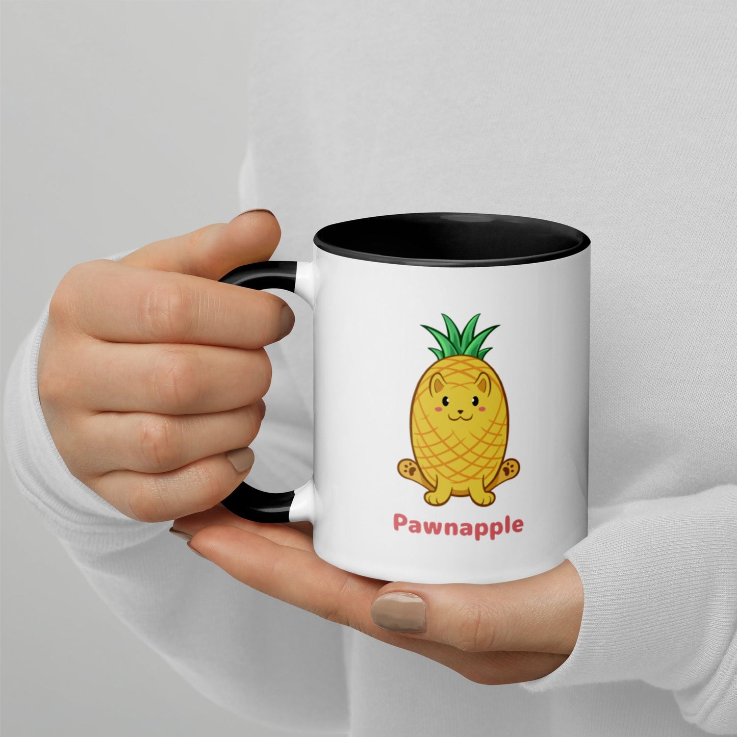 Hands holding a white and black Coffee Mug with Pawnapple⢠print. Pawnapple⢠is a pineapple drawn as a cute cat.