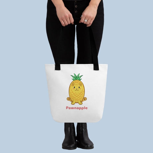 Person holding a white Tote Bag with Pawnapple⢠print. Pawnapple⢠is a pineapple drawn as a cute cat.