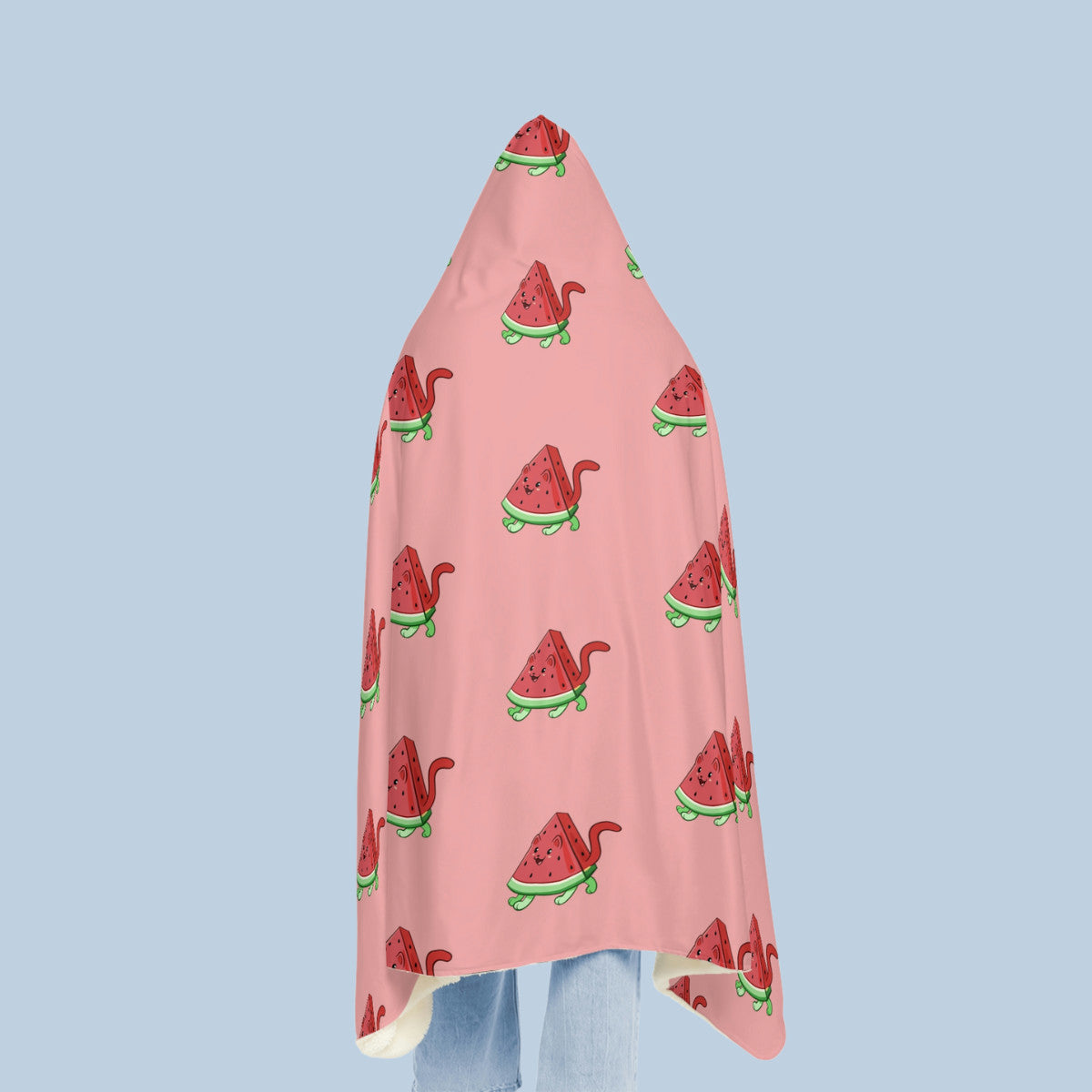 Happy woman wearing the pink Watermewlon⢠hooded microfiber fleece blanket seen from behind. Watermewlon⢠is a watermelon drawn as a cute cat.