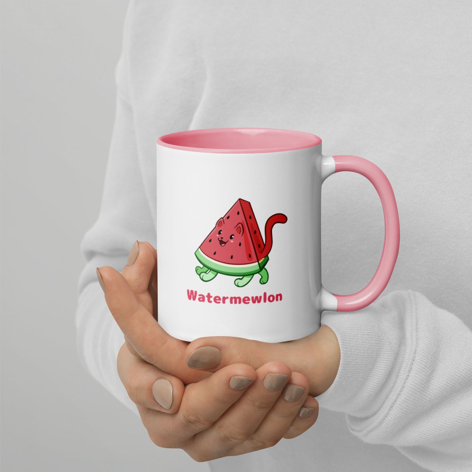 Hands holding a white and pink Coffee Mug with Watermewlon⢠print. Watermewlon⢠is a watermelon drawn as a cute cat.