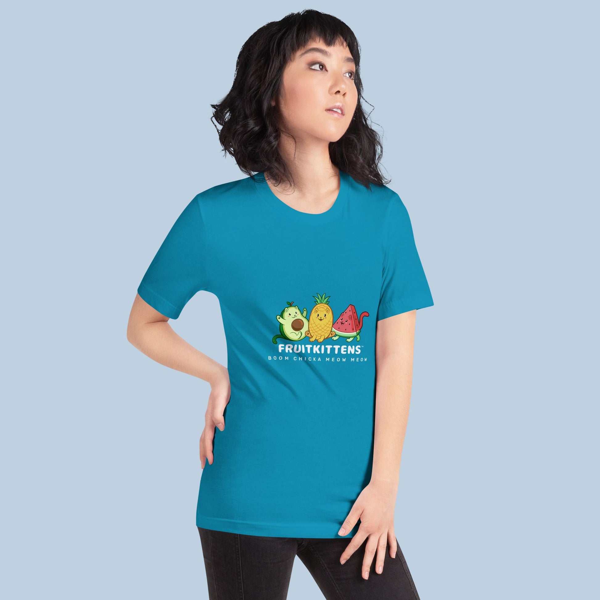 Woman wearing an aqua blue T-Shirt with Fruitkittens⢠logo. Fruitkittens⢠are fruits drawn as cute cats. The logo features Pawocadoâ˘, Pawnapple⢠and Watermewlonâ˘.