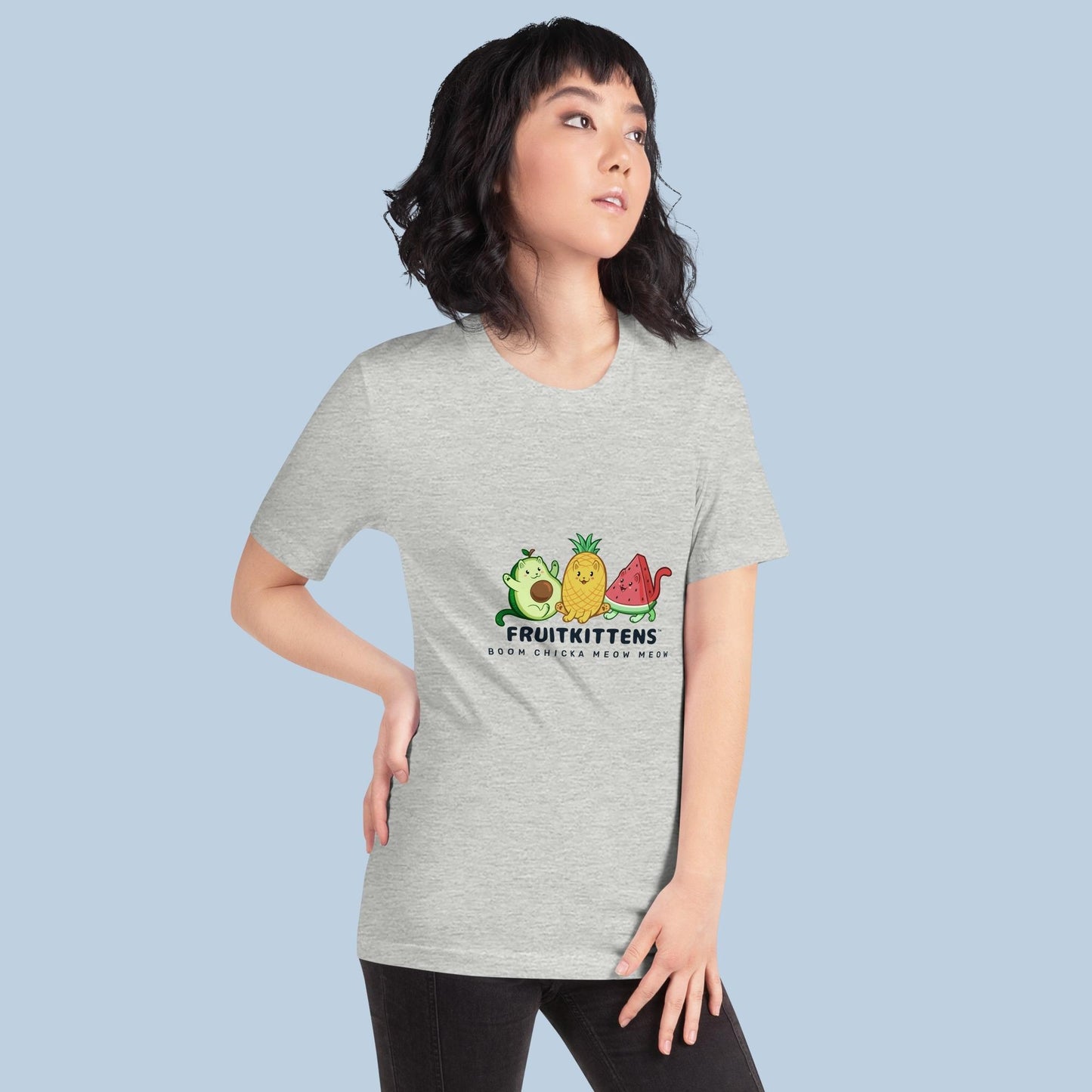 Woman wearing an athletic heather grey T-Shirt with Fruitkittens⢠logo. Fruitkittens⢠are fruits drawn as cute cats. The logo features Pawocadoâ˘, Pawnapple⢠and Watermewlonâ˘.