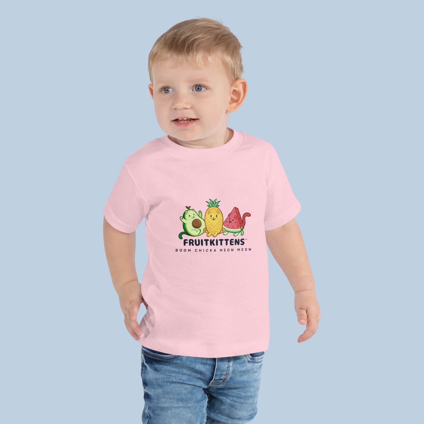 Toddler wearing a pink Toddler T-Shirt with Fruitkittens⢠logo. Fruitkittens⢠are fruits drawn as cute cats. The logo features Pawocadoâ˘, Pawnapple⢠and Watermewlonâ˘.