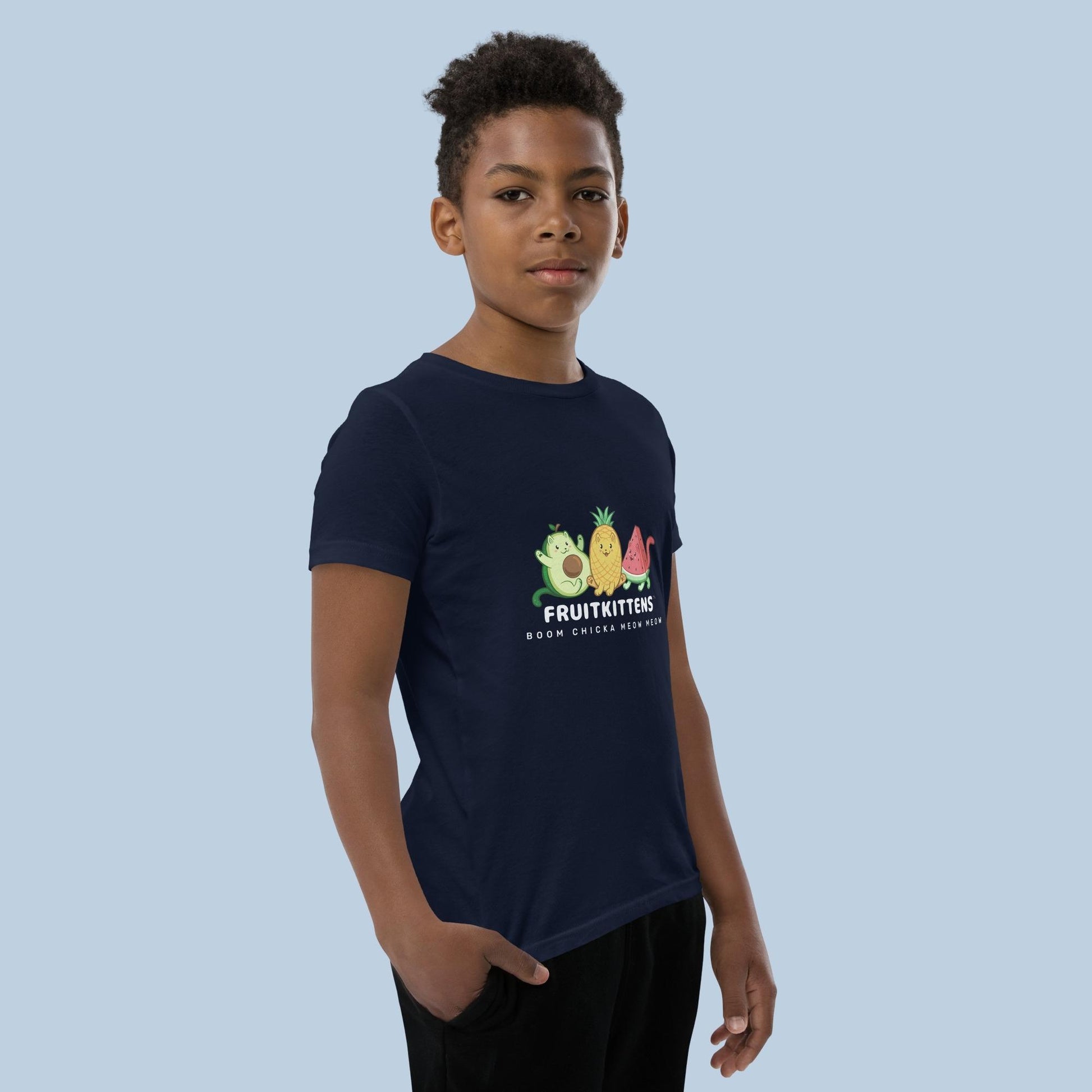 Boy wearing a navy blue T-Shirt with Fruitkittens⢠logo. Fruitkittens⢠are fruits drawn as cute cats. The logo features Pawocadoâ˘, Pawnapple⢠and Watermewlonâ˘.