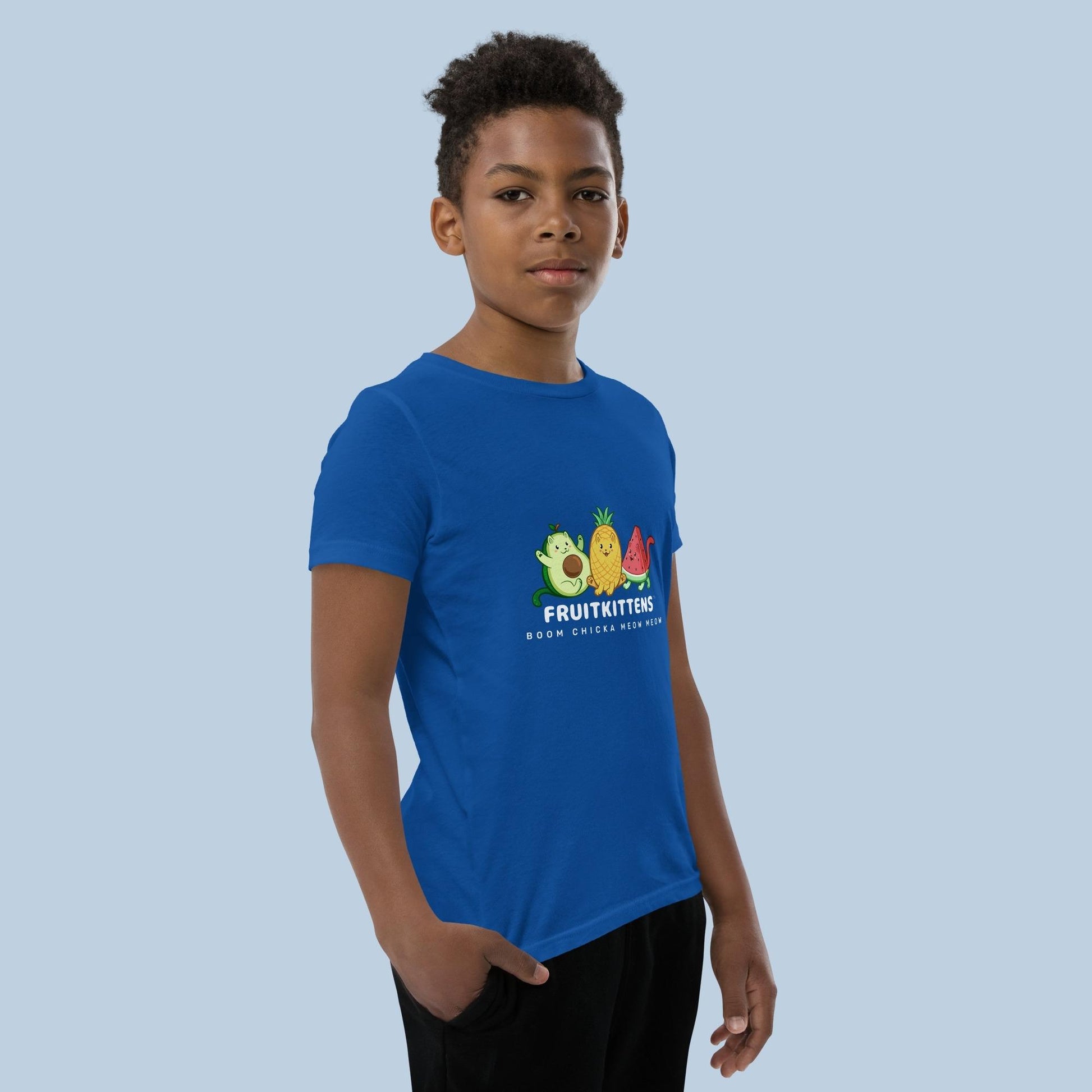 Boy wearing a royal blue T-Shirt with Fruitkittens⢠logo. Fruitkittens⢠are fruits drawn as cute cats. The logo features Pawocadoâ˘, Pawnapple⢠and Watermewlonâ˘.