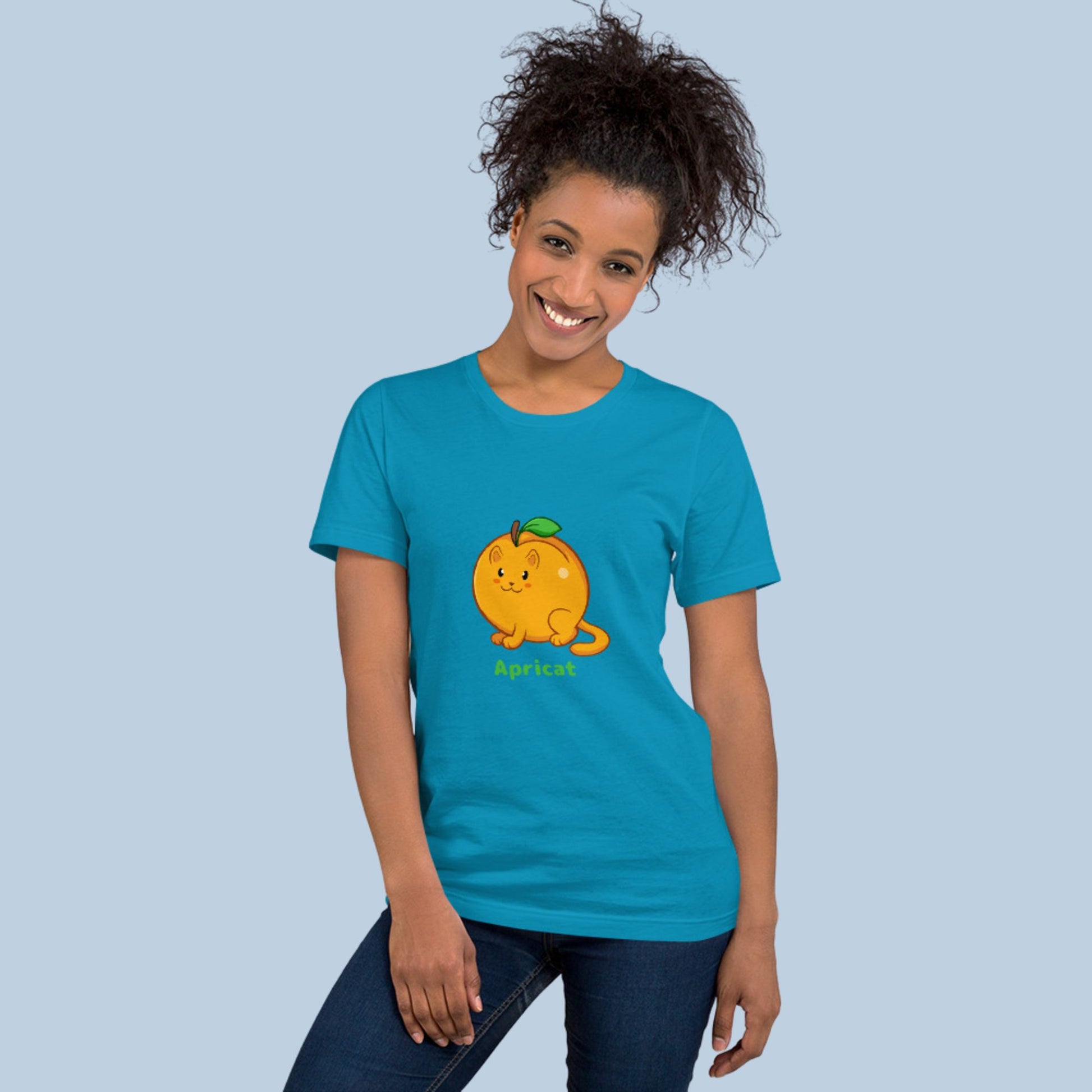 Woman wearing an aqua blue T-Shirt with Apricat™ print. Apricat™ is an apricot drawn as a cute cat.