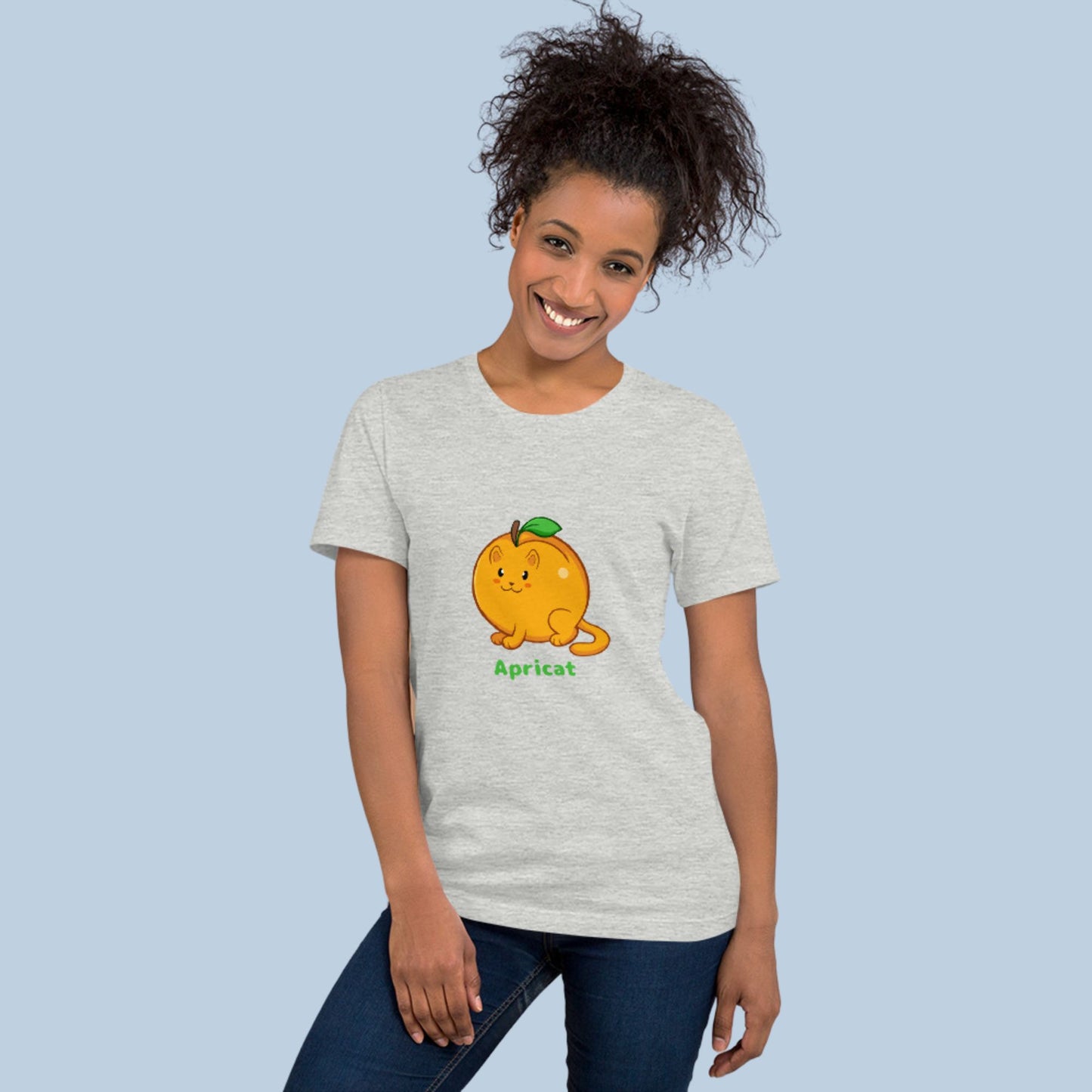 Woman wearing an athletic heather grey T-Shirt with Apricat™ print. Apricat™ is an apricot drawn as a cute cat.