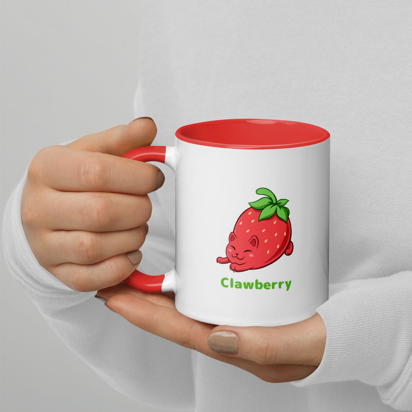 Hands holding a white and red Coffee Mug with Clawberry™ print. Clawberry™ is a strawberry drawn as a cute cat.