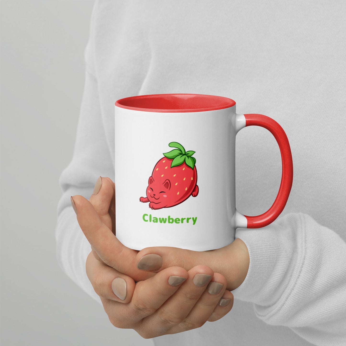 Hands holding a white and red Coffee Mug with Clawberry™ print. Clawberry™ is a strawberry drawn as a cute cat.