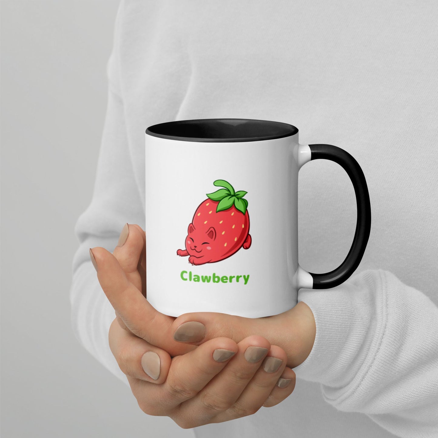 Hands holding a white and black Coffee Mug with Clawberry™ print. Clawberry™ is a strawberry drawn as a cute cat.