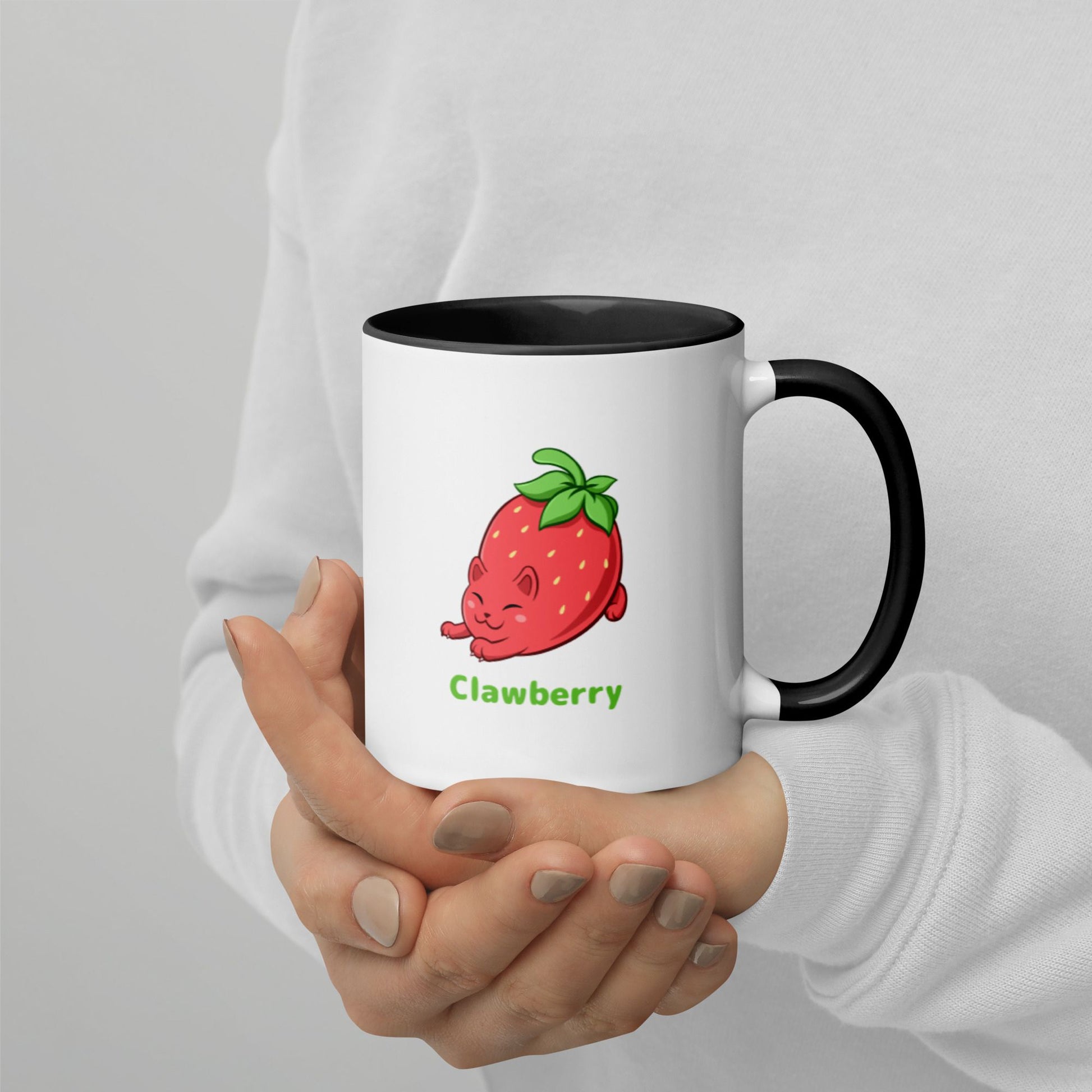 Hands holding a white and black Coffee Mug with Clawberry™ print. Clawberry™ is a strawberry drawn as a cute cat.