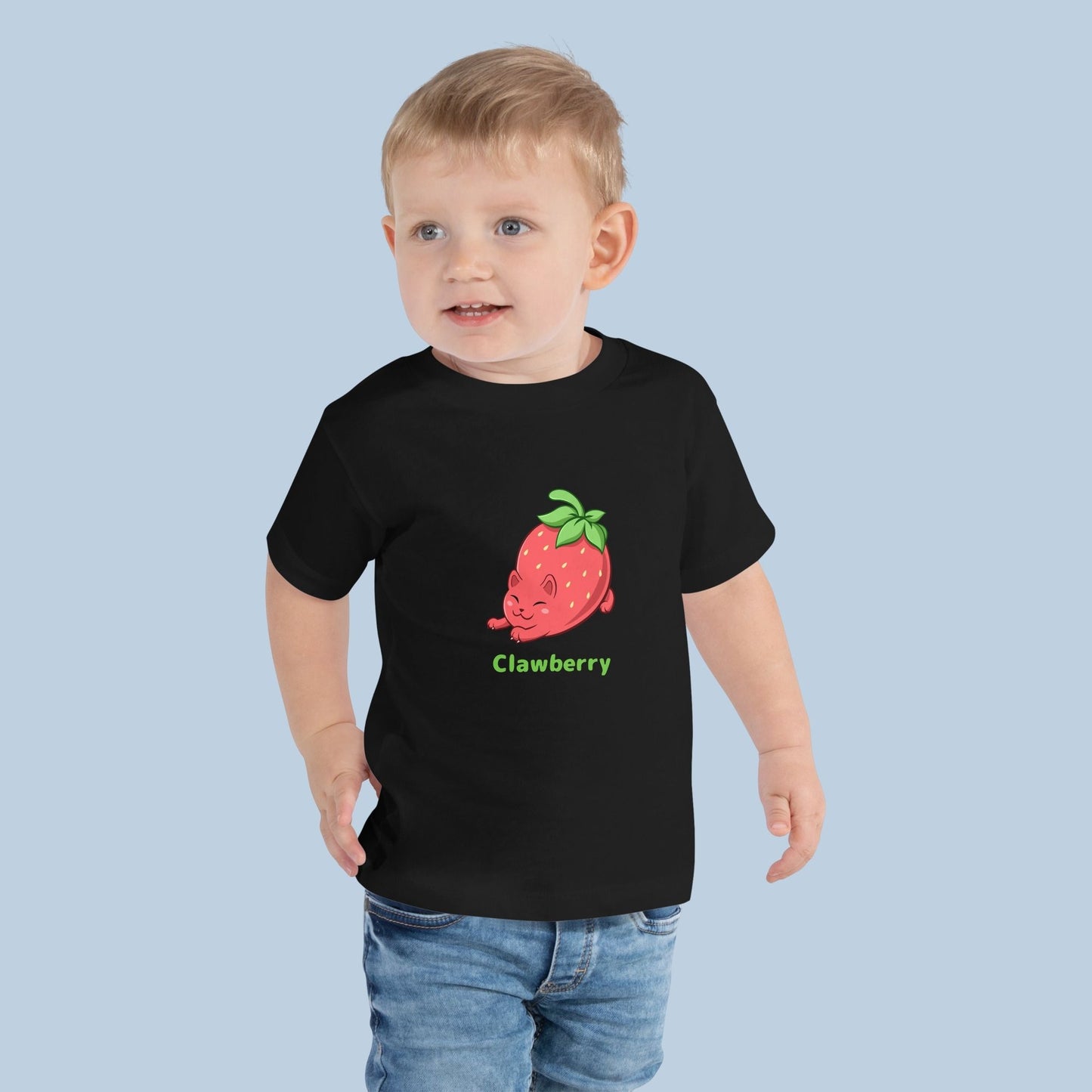 Toddler wearing a black Toddler T-Shirt with Clawberry™ print. Clawberry™ is a strawberry drawn as a cute cat.