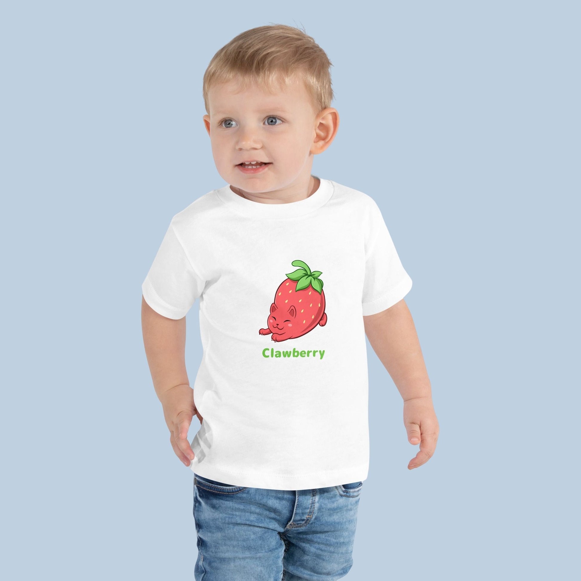 Toddler wearing a white Toddler T-Shirt with Clawberry™ print. Clawberry™ is a strawberry drawn as a cute cat.