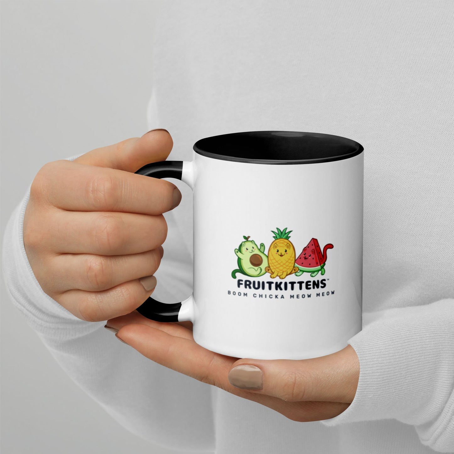 Hands holding a white and black Coffee Mug with with Fruitkittens™ logo. Fruitkittens™ are fruits drawn as cute cats. The logo features Pawocado™, Pawnapple™ and Watermewlon™