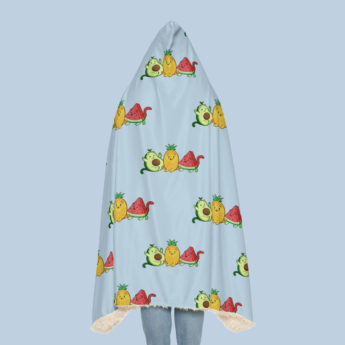 Happy woman wearing the light blue Fruitkittens™ logo hooded sherpa blanket seen from behind. Fruitkittens™ are fruits drawn as cute cats. The logo features Pawocado™, Pawnapple™ and Watermewlon™