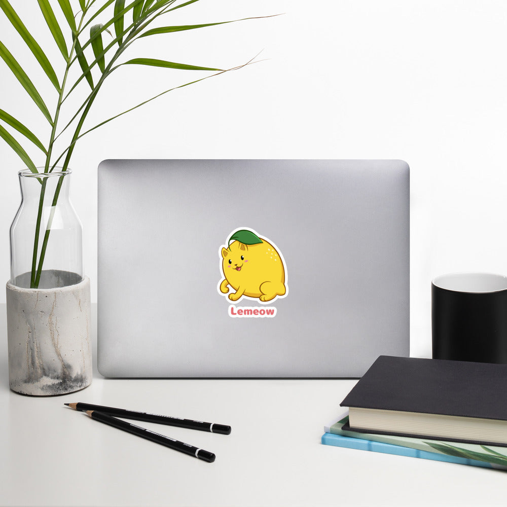 5.5 x 5.5 inch Sticker with Lemeow™ print. The sticker is on a laptop. Lemeow™ is a lemon drawn as a cute cat.