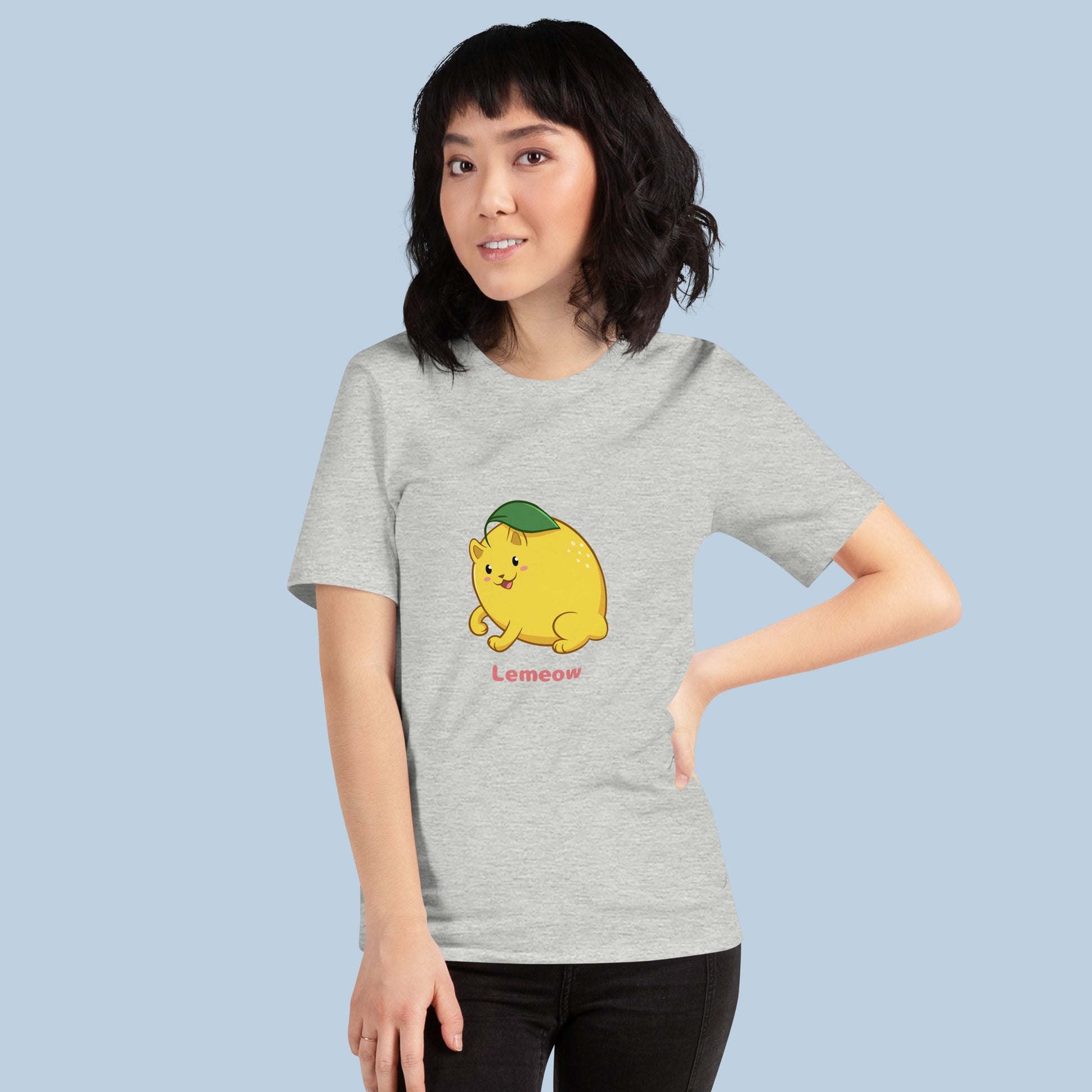 Woman wearing an athletic heather grey T-Shirt with Lemeow™ print. Lemeow™ is a lemon drawn as a cute cat.