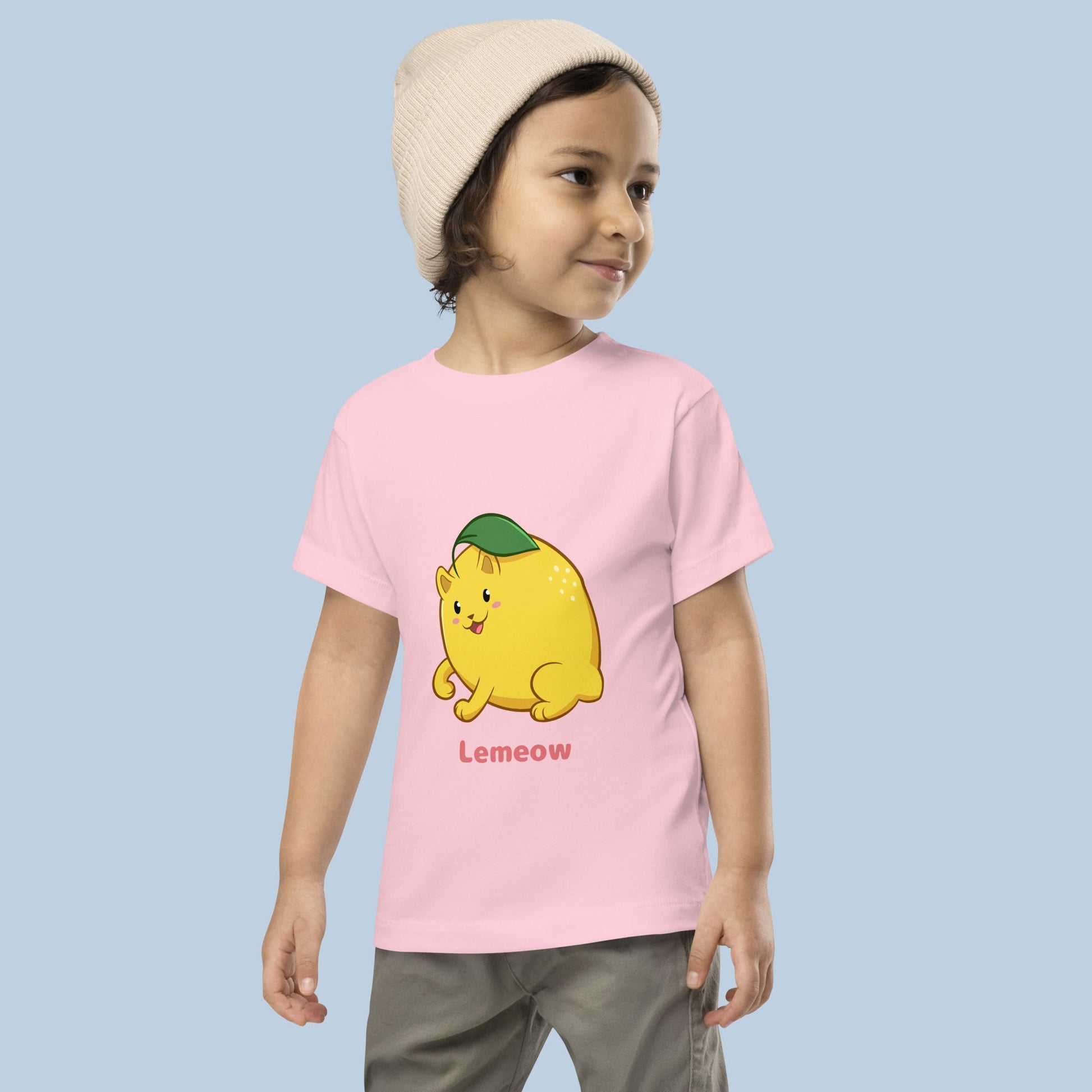 Toddler wearing a pink Toddler T-Shirt with Lemeow™ print. Lemeow™ is a lemon drawn as a cute cat.