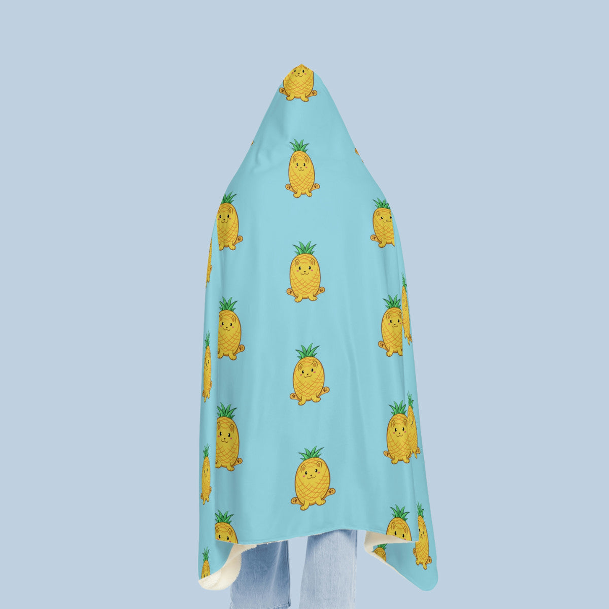 Happy woman wearing the light blue Pawnapple™ hooded microfiber fleece blanket seen from behind. Pawnapple™ is a pineapple drawn as a cute cat.