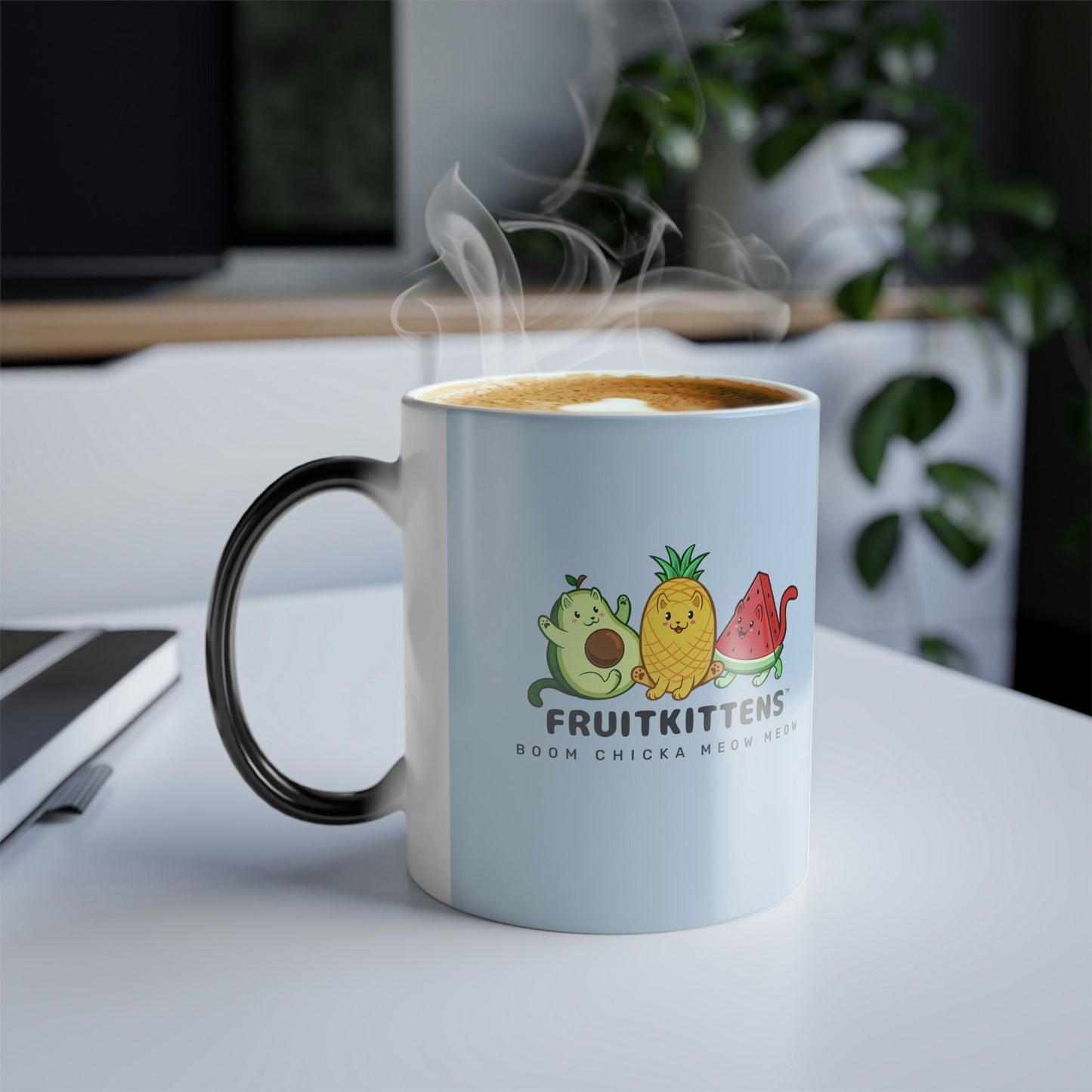 Light Blue Magic Mug with Fruitkittens™ logo standing on an office desk. Fruitkittens™ are fruits drawn as cute cats. The logo features Pawocado™, Pawnapple™ and Watermewlon™